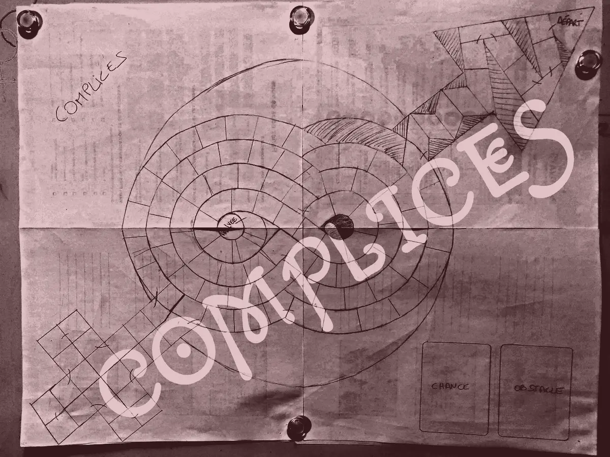 Croquis au crayon d’un plateau de jeu : deux spirales, une flèche, une croix et le mot COMPLICES.